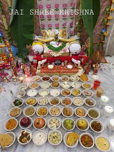 there are many bowls on the table with food in front of it and an idol behind them