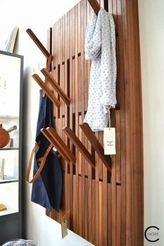 a wooden coat rack with clothes hanging on it