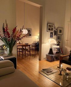 a living room filled with furniture next to a dining room table and chairs on top of a hard wood floor