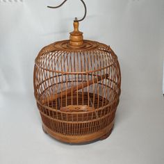 a bird in a cage sitting on top of a white table next to a lamp