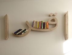 a book shelf with books on it next to a wall mounted sign that says love