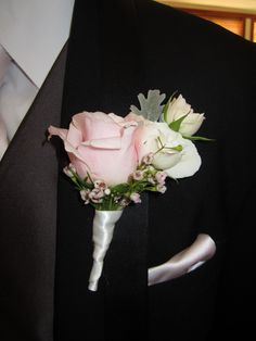 a boutonniere with pink and white flowers on it's lapel