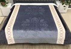 a bed with a blue and white comforter on top of it