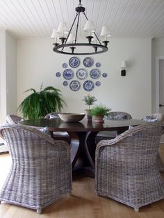 a dining room table with chairs and plates on the wall