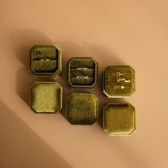 four small trays with rings in them sitting on a table