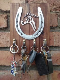 a horse head is mounted to the side of a brick wall with several key hooks