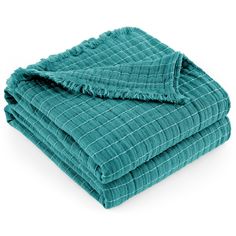 the teal blanket is folded on top of each other