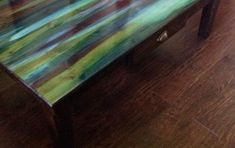 a coffee table painted with multicolored paint on it's top and legs