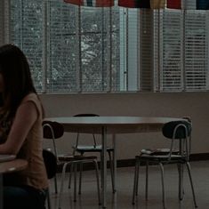 a woman sitting at a table in front of a laptop computer