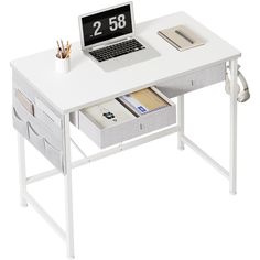 a laptop computer sitting on top of a white desk with drawers underneath it and an alarm clock next to it