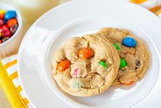 two cookies with m & m candies are on a white plate