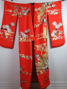 "Vintage 1960s mid century modern wedding kimono robe. Made of bright red/orange silk with metallic silver and gold embroidery. Long kimono with a padded trim hem at bottom. About a size medium. Actual measurements are: 51\" at the bust 51\" at the waist 24.5\" shoulder seam to shoulder seam 13\" shoulder seam to cuff 70\" overall length In very good condition. Has some wear to the bottom edge(photo)." Long Vintage Kimono For Festivals, Vintage Long Kimono For Wedding, Long Embroidered Kimono For Wedding, Wedding Embroidered Kimono With Kimono Sleeves, Vintage Long Red Kimono, Vintage Red Long Kimono, Ceremonial Vintage Kimono, Traditional Long Orange Kimono, Vintage Wedding Kimono With Kimono Sleeves