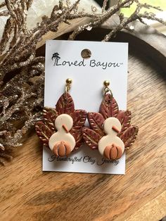 a pair of earrings sitting on top of a wooden table