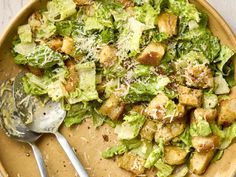 a plate filled with lettuce and croutons covered in parmesan cheese