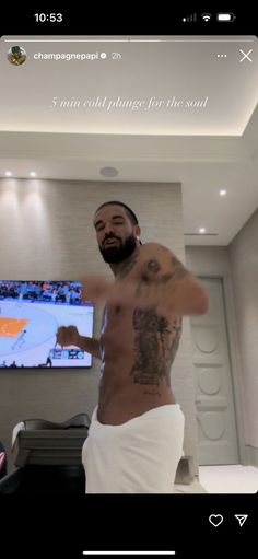 a man standing in front of a flat screen tv with his shirt off and tattoos on