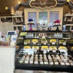 a display case in a bakery filled with lots of cakes and cupcakes for sale