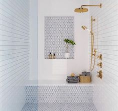 a bathroom with blue and white tile on the walls, shower head, and bathtub