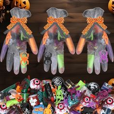 three plastic gloves with halloween decorations on them next to pumpkins and spider webs