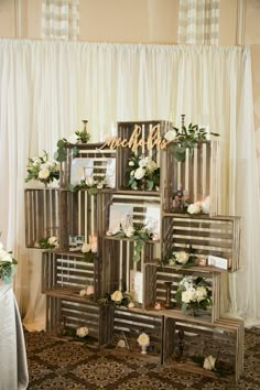 an arrangement of wooden crates with flowers on them