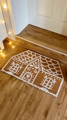 a brown and white door mat sitting on top of a wooden floor next to a doorway