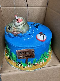 there is a cake in the shape of a fish with fishing signs on it and a sign that says gone fishing