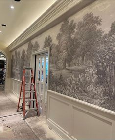 a man is painting a mural on the wall in a room that has been renovated