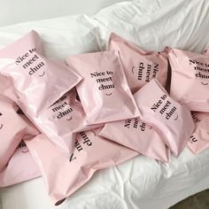 a pile of bags sitting on top of a bed covered in white sheets and pillows