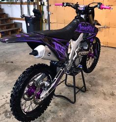 a purple and black dirt bike parked in a garage