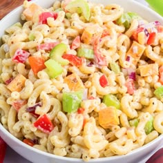 a white bowl filled with macaroni salad on top of a table