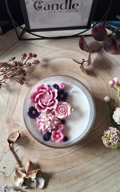 a bowl filled with flowers sitting on top of a wooden table