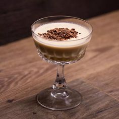 a dessert in a glass on top of a wooden table