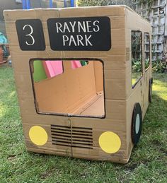 a cardboard box shaped like a bus with the door open and numbers 3, 5, and 7 on it