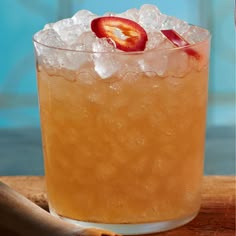 a close up of a drink in a glass with ice and fruit on the rim