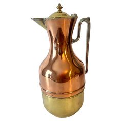 a shiny metal pitcher with a gold rim