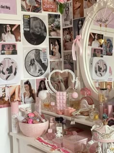 a vanity with pink accessories and pictures on the wall