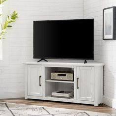 a flat screen tv sitting on top of a wooden entertainment center in a living room