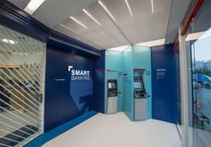 an atm machine in the middle of a room with blue walls and glass doors that say smart bank