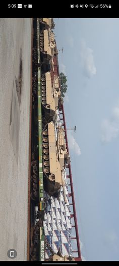 several vehicles are lined up next to each other on the side of a building with ladders