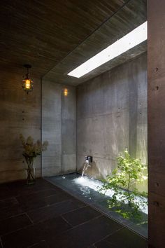 an indoor water feature in the corner of a room with concrete walls and flooring