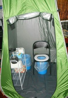 a green tent with two blue buckets in it