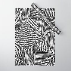 a pen is laying on top of a black and white patterned piece of art paper