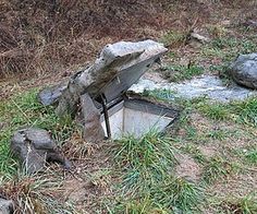 an old broken toilet sitting in the middle of some grass and rocks with water coming out of it