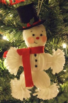 a snowman ornament hanging from a christmas tree