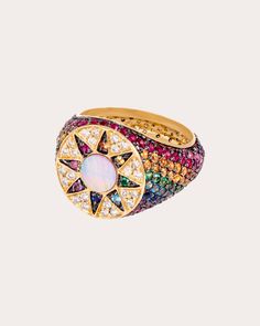 Based in solid 18-karat gold, this statement ring decorates its tapered band with a rainbow-hued array of genuine gemstones. The circular face features a sun motif created from inlaid mother of pearl for iridescent appeal. From L'Atelier Nawbar’s Cosmic Love Collection, inspired by the heavenly bodies that adorn our skies, sun, moon, horoscopes, constellations and zodiac signs. 18k yellow gold, mother of pearl, emerald, yellow sapphire, orange sapphire, blue sapphire, pink sapphire, ruby, blue t Pink Saphire, Sun Motif, Cosmic Love, Family Ring, Heavenly Bodies, Family Rings, Turtle Dove, High Jewellery, Rainbow Rings