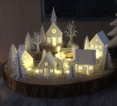 a small christmas village with lit up houses and trees