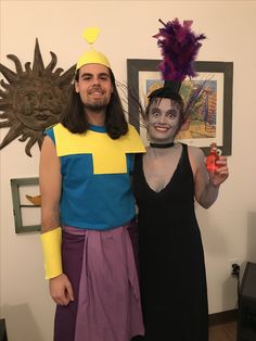 a man and woman dressed up in costumes posing for a photo with a paper mache on his face