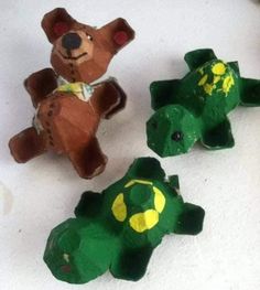 three paper mache animals sitting next to each other on a white counter top in front of a brown teddy bear