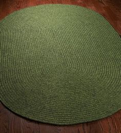 a green rug on a wooden floor