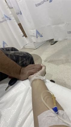 an injured person is laying on the floor with his arm wrapped in medical gauze