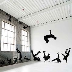 the silhouettes of people doing tricks in an empty room